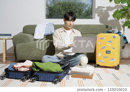 A man in his 20s preparing for a trip A man in his 20s preparing for a trip 120010010