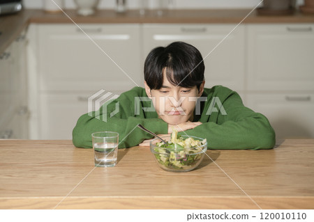 A man in his 20s managing his diet by eating salad A man in his 20s managing his diet by eating salad 120010110
