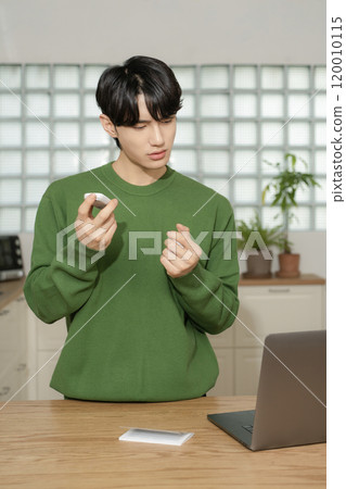 A man in his 20s uses a laptop to look up information to manage blood sugar levels 120010115