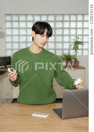 A man in his 20s uses a laptop to look up information to manage blood sugar levels A man in his 20s uses a laptop to look up information to manage blood sugar levels 120010116