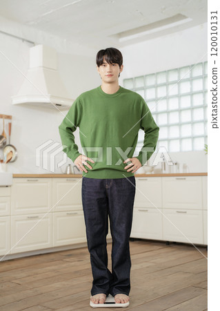 A man in his 20s measuring his weight on a scale A man in his 20s measuring his weight on a scale 120010131