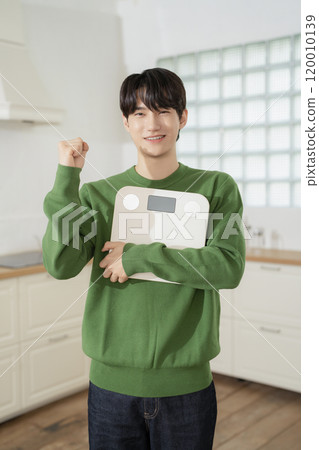 A man in his 20s holding a scale and making a resolution 120010139