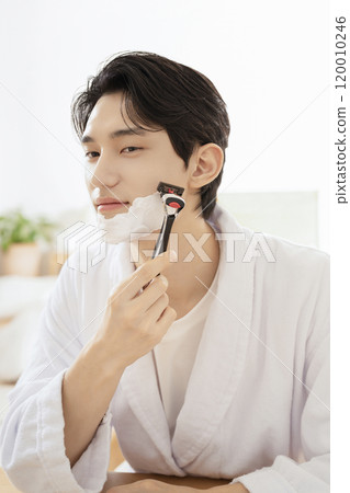 A man in his 20s shaving in front of a mirror A man in his 20s shaving in front of a mirror 120010246