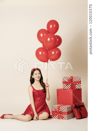 A woman in her 20s posing with a balloon 120010370