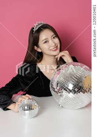 A woman in her 20s posing in front of a mirror ball A woman in her 20s posing in front of a mirror ball 120010401
