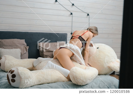 Woman Playing With Large White Plush Bear in Bedroom 120010586