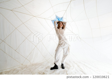Woman Posing in White Clothing Against a White Background With String Lights Woman Posing in White Clothing Against a White Background With String Lights 120010621