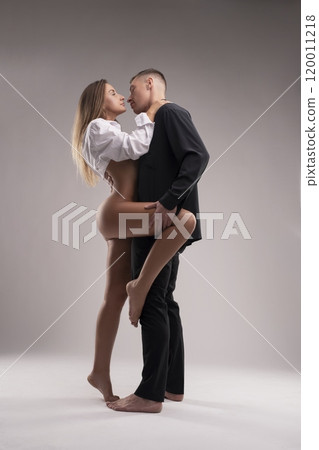 Loving couple embracing and looking at each other in studio 120011218