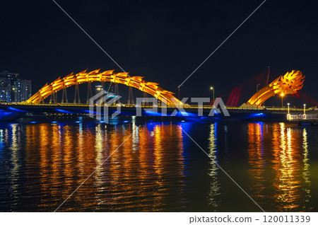 Dragon Bridge over Han River in city of Da Nang in Vietnam at night with a golden backlight Dragon Bridge over Han River in city of Da Nang in Vietnam at night with a golden backlight 120011339