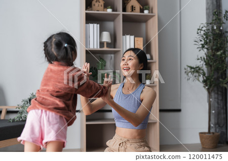 Mother and Child Practicing Yoga Together at Home in a Bright and Cozy Living Room Setting Mother and Child Practicing Yoga Together at Home in a Bright and Cozy Living Room Setting 120011475