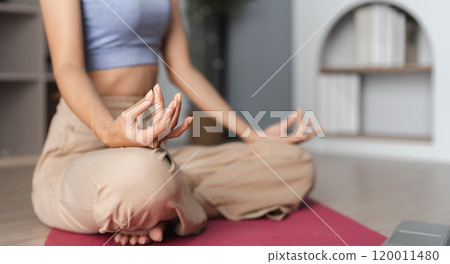 Young Woman Practicing Yoga and Meditation Indoors for Relaxation and Mindfulness in a Modern Home Setting Young Woman Practicing Yoga and Meditation Indoors for Relaxation and Mindfulness in a Modern Home Setting 120011480