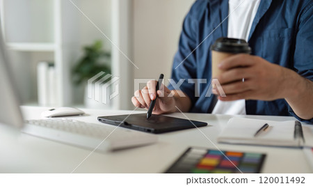 Graphic Designer Selecting Color Pairs on Computer for Creative Design Projects in Modern Workspace with Digital Tools and Coffee 120011492