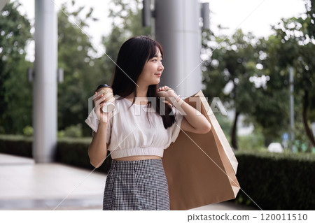 Young Woman Shopping with Paper Bag at Department Store, Embracing Modern Retail Experience with Style and Elegance Young Woman Shopping with Paper Bag at Department Store, Embracing Modern Retail Experience with Style and Elegance 120011510