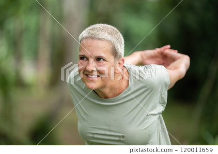 Elderly Woman Practicing Yoga Outdoors in a Lush Garden Setting for Health and Wellness 120011659