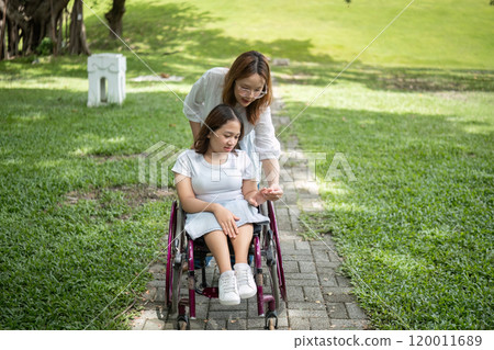 Young Disabled Woman and Best Friend Enjoying Outdoor Activities Together in a Park Setting 120011689