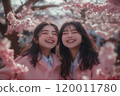 兩個友善的女孩在櫻花盛開的地方燦爛地微笑 120011780
