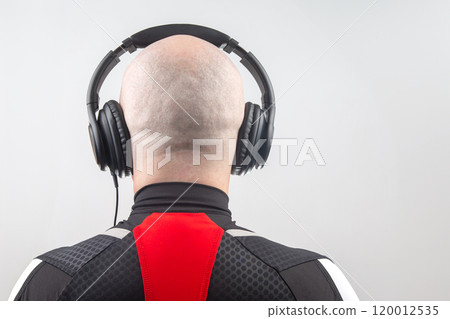 head of a man from behind in headphones listening to music 120012535