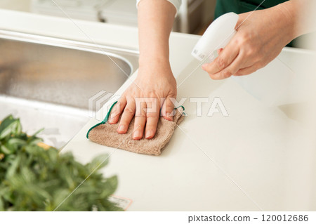 The hands of a middle-aged to senior woman wiping the kitchen with a cloth The hands of a middle-aged to senior woman wiping the kitchen with a cloth 120012686