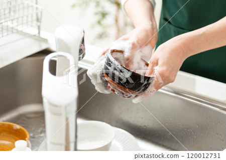 The hands of a middle-aged to senior woman washing bowls in the kitchen 120012731