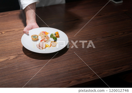 Male chef's hands serving food Male chef's hands serving food 120012746