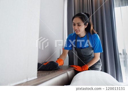 Cleaning service woman cleans dust on the headboard with a cloth. House cleaning service concept 120013131