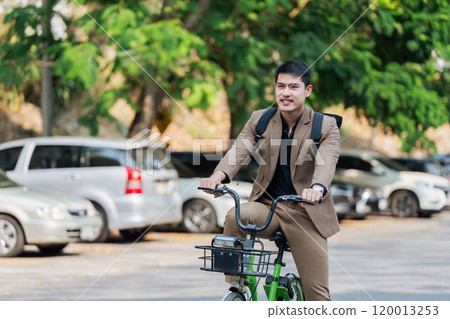 Young businessman ride bicycle to work. Reduce global warming Help save energy. Eco friendly concept Young businessman ride bicycle to work. Reduce global warming Help save energy. Eco friendly concept 120013253