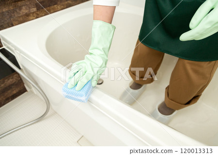Hands of a middle-aged to senior woman cleaning the bathtub Hands of a middle-aged to senior woman cleaning the bathtub 120013313