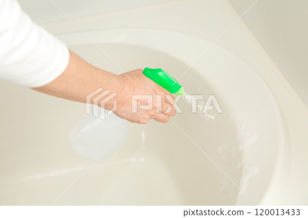Hands of a middle-aged to senior woman cleaning the bathtub 120013433