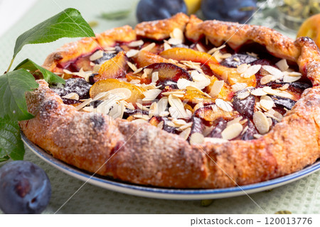 Open pie (galette) with plums close up. 120013776