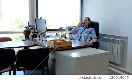 Caucasian woman sits in office talking on phone and negotiating business deal modern woman. Corporate office mid adult female engaged in telephone conversation conducting conversation. 120014045