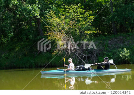 Family kayak trip for seigneur and senora. An elderly married couple rowing a boat on the river, a water hike, a summer adventure. Age-related sports, mental youth and health, tourism, active old age Family kayak trip for seigneur and senora. An elderly married couple rowing a boat on the river, a water hike, a summer adventure. Age-related sports, mental youth and health, tourism, active old age 120014341