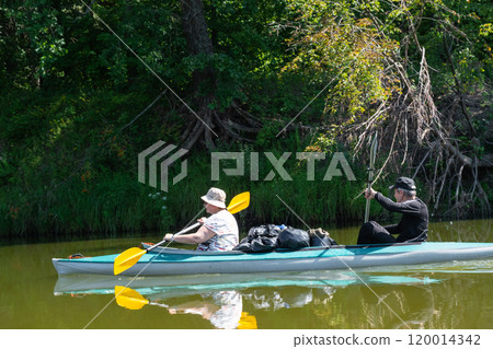 Family kayak trip for seigneur and senora. An elderly married couple rowing a boat on the river, a water hike, a summer adventure. Age-related sports, mental youth and health, tourism, active old age 120014342