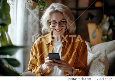 Close up happy older woman using her smartphone, typing message, choose goods, buying services, enjoy remote chat with friend or online communication, read news, check planner or organizer using app 120014846