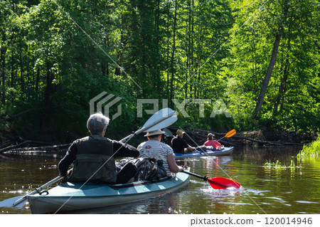 Group kayak trip for seigneur and senora . An elderly couple And adult rowing boat on the river, a water hike, a summer adventure. Age-related sports, mental youth and health, tourism, active old age 120014946
