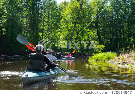 Group kayak trip for seigneur and senora . An elderly couple And adult rowing boat on the river, a water hike, a summer adventure. Age-related sports, mental youth and health, tourism, active old age 120014947