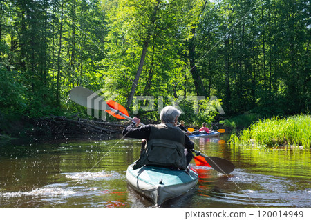 Group kayak trip for seigneur and senora . An elderly couple And adult rowing boat on the river, a water hike, a summer adventure. Age-related sports, mental youth and health, tourism, active old age 120014949