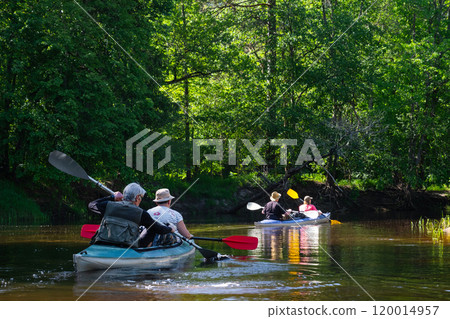 Group kayak trip for seigneur and senora . An elderly couple And adult rowing boat on the river, a water hike, a summer adventure. Age-related sports, mental youth and health, tourism, active old age 120014957