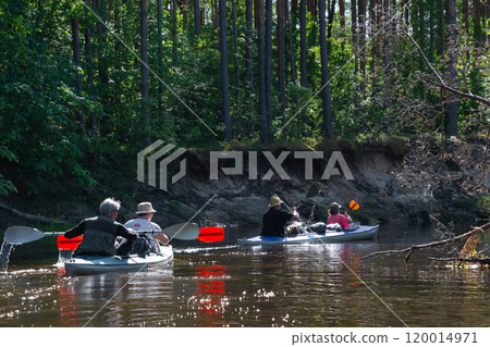 Group kayak trip for seigneur and senora . An elderly couple And adult rowing boat on the river, a water hike, a summer adventure. Age-related sports, mental youth and health, tourism, active old age 120014971