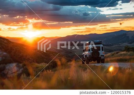 A car is driving down a road with a beautiful sunset in the background 120015376