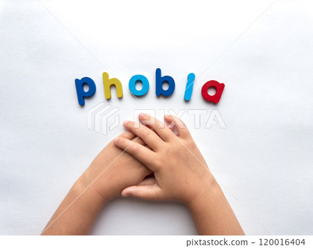 Childrens hands holding in anxiety concept with colorful phobia letters on white background 120016404