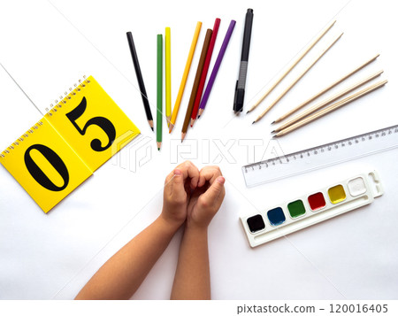 Creative workspace with art supplies and yellow calendar on white background 120016405