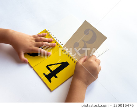 Child learning numbers with a colorful educational flip book 120016476