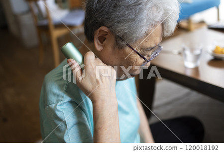 Senior woman massaging stiff shoulders Senior woman massaging stiff shoulders 120018192