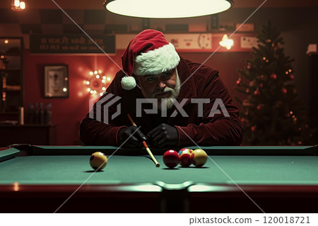 A man in a santa hat playing pool in a room with a Christmas tree 120018721