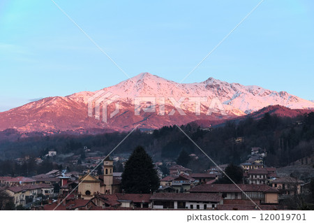 profile of a Piedmont alp overlooks the Po Valley immersed in a pink sunset 120019701