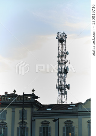 urban electromagnetic pollution: a huge telephone antenna mounted between the roofs of houses urban electromagnetic pollution: a huge telephone antenna mounted between the roofs of houses 120019736