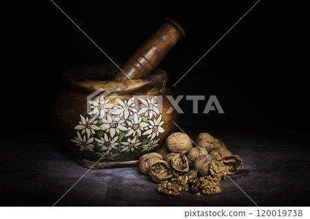 handmade wooden mortar with alpine decorations and nuts to beat 120019738