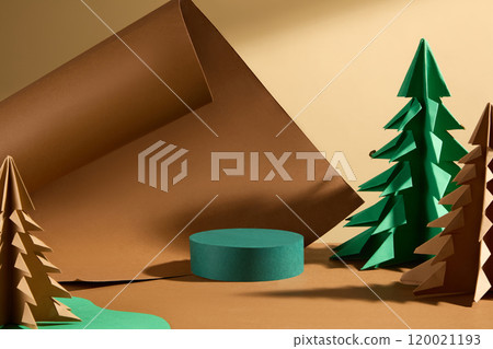 Emerald green circular podium with product display space, set on a brown surface with a beige background, surrounded by various paper pines and brown paper. Warm-tone Christmas theme image template. 120021193