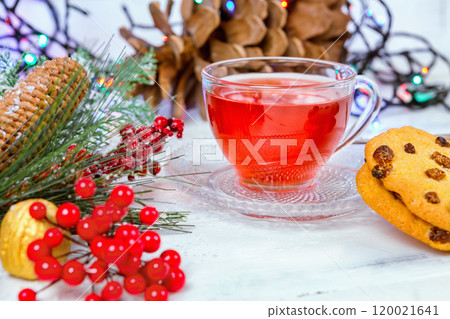 Christmas tea in glass Cup . composition with cookie, pine branches, cones on background of garlands on wooden table Christmas tea in glass Cup . composition with cookie, pine branches, cones on background of garlands on wooden table 120021641