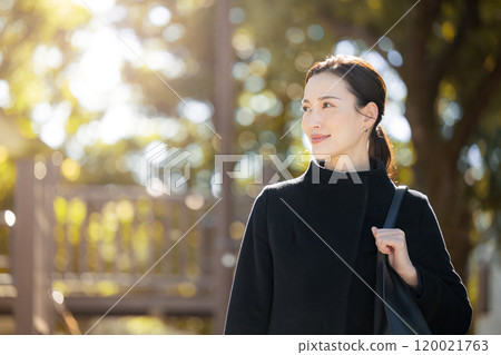 中秋和冬季,一位女士像商業銷售員一樣走來走去,秋葉背光 中秋和冬季,一位女士像商業銷售員一樣走來走去,秋葉背光 120021763